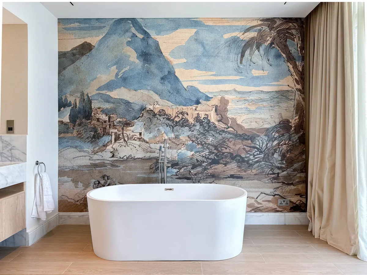 Freestanding white bathtub in front of a large landscape mural wall in a Dubai apartment